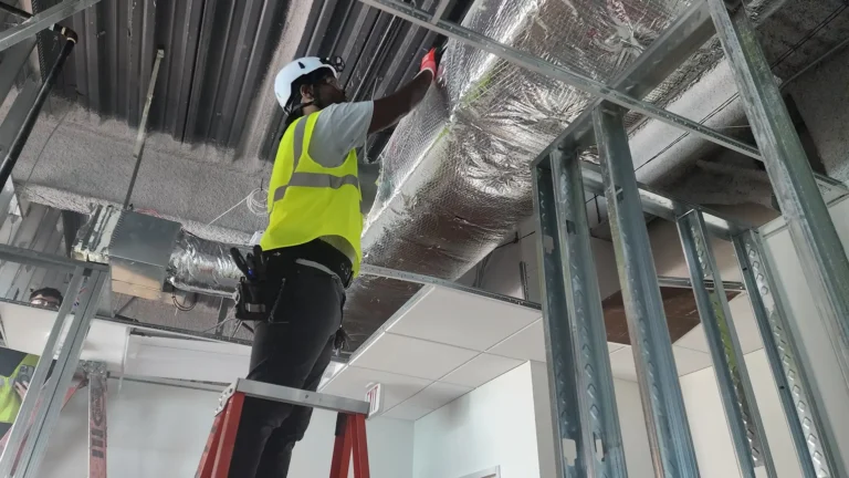 Installer routing low-voltage wiring above ceiling during system installation