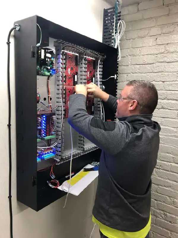 Technician wiring a commercial access control panel
